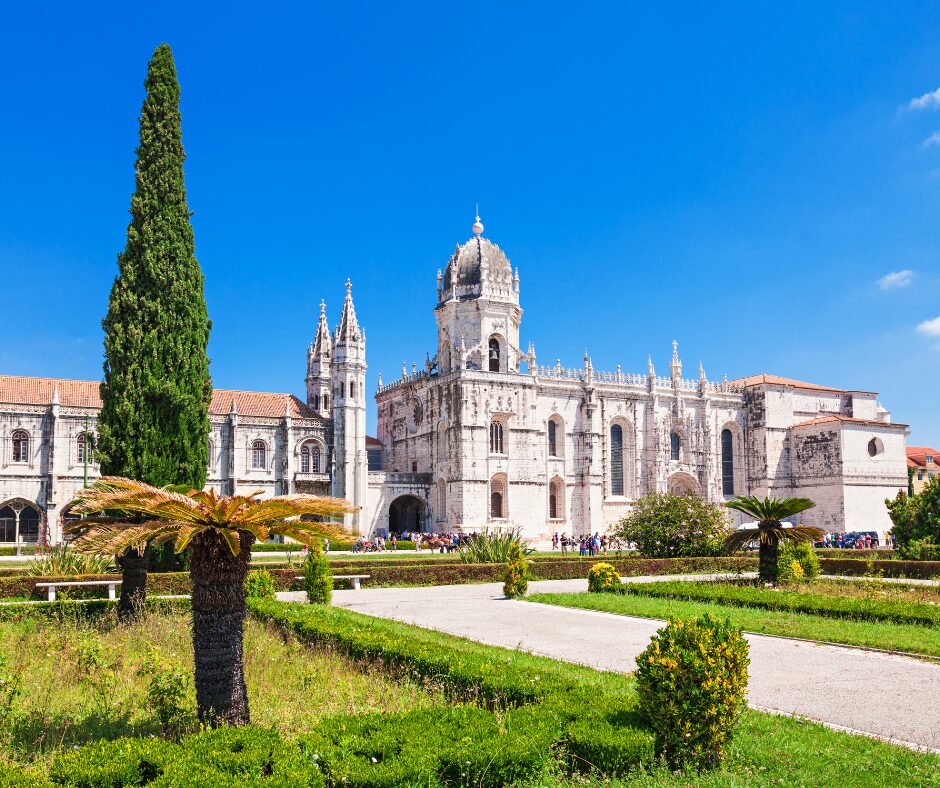a large white building with a tower and a garden